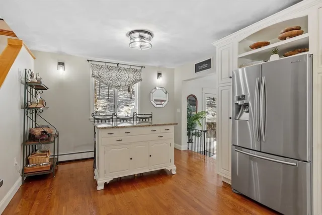 a kitchen with stainless steel appliances a refrigerator and wooden floor