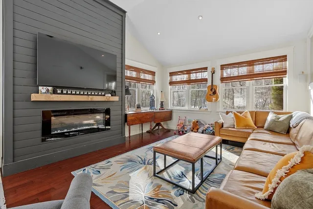 a living room with furniture a large window and a fireplace
