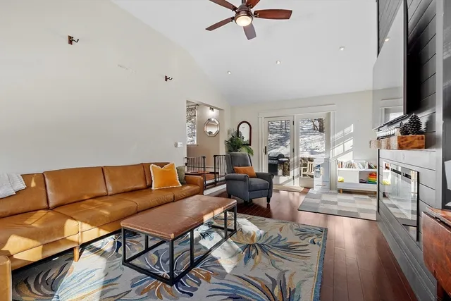 a living room with furniture a flat screen tv and a fireplace