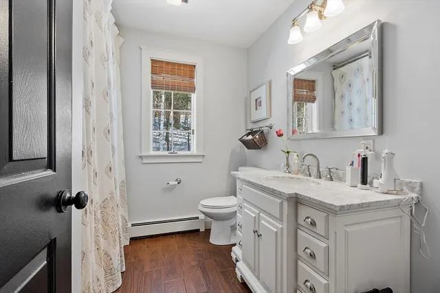 a bathroom with a granite countertop toilet sink and mirror