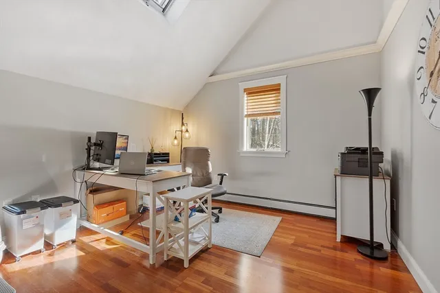 a view of a workspace with furniture and a window