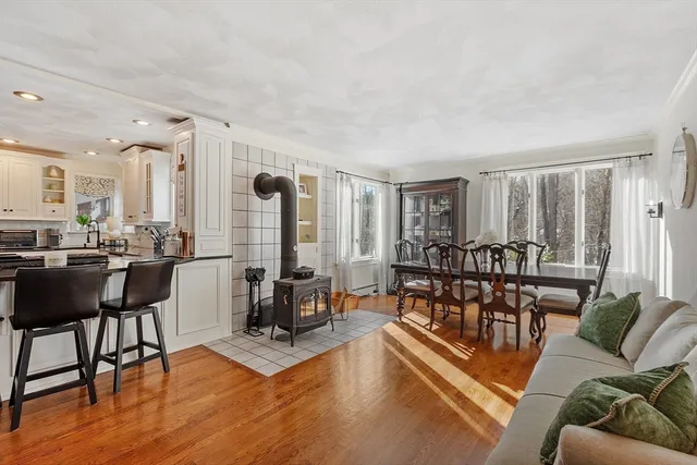 a living room with furniture a large window and wooden floor