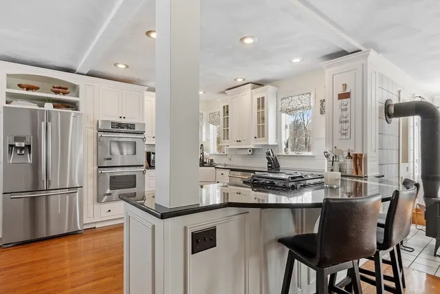 a kitchen with stainless steel appliances granite countertop a stove refrigerator sink and cabinets