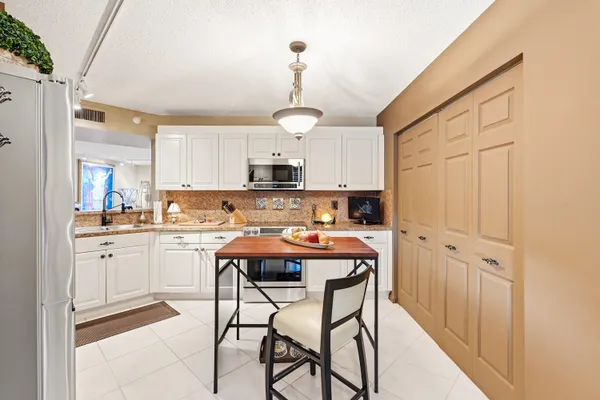 a kitchen with stainless steel appliances granite countertop a white cabinets and wooden floor