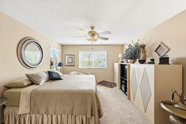 a bedroom with a bed a mirror and a window