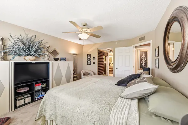 a bedroom with a bed a flat screen tv and a couch