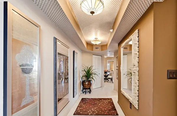 a very nice looking hallway with wooden floor and a chandelier