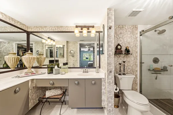 a bathroom with a granite countertop sink mirror vanity and toilet