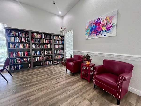 a living room with furniture a bookshelf and a wooden floor