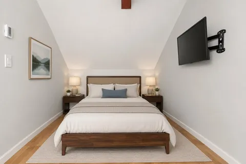 a bedroom with a large bed and a flat screen tv