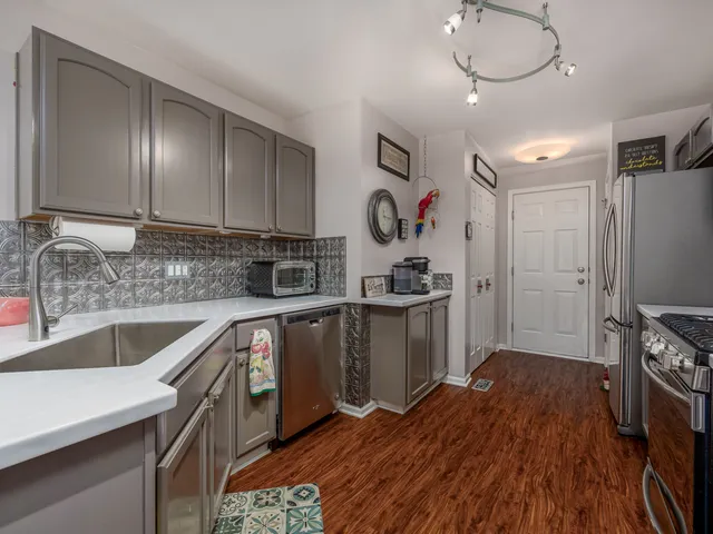 a kitchen with a sink a refrigerator and cabinets
