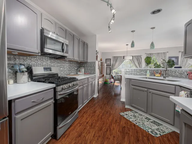 a kitchen with stainless steel appliances granite countertop a lot of counter space and wooden floors