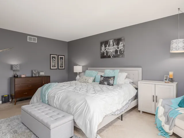 a bedroom with a bed and a chandelier