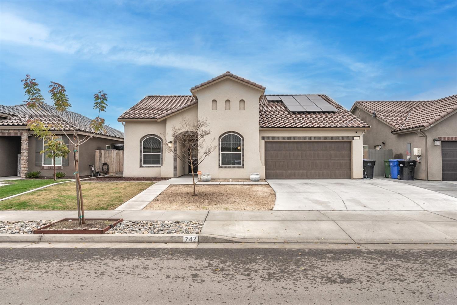 742 Strada Street Lemoore, CA 93245 - Photo 1 of 40 a large white house with a white roof and a yard