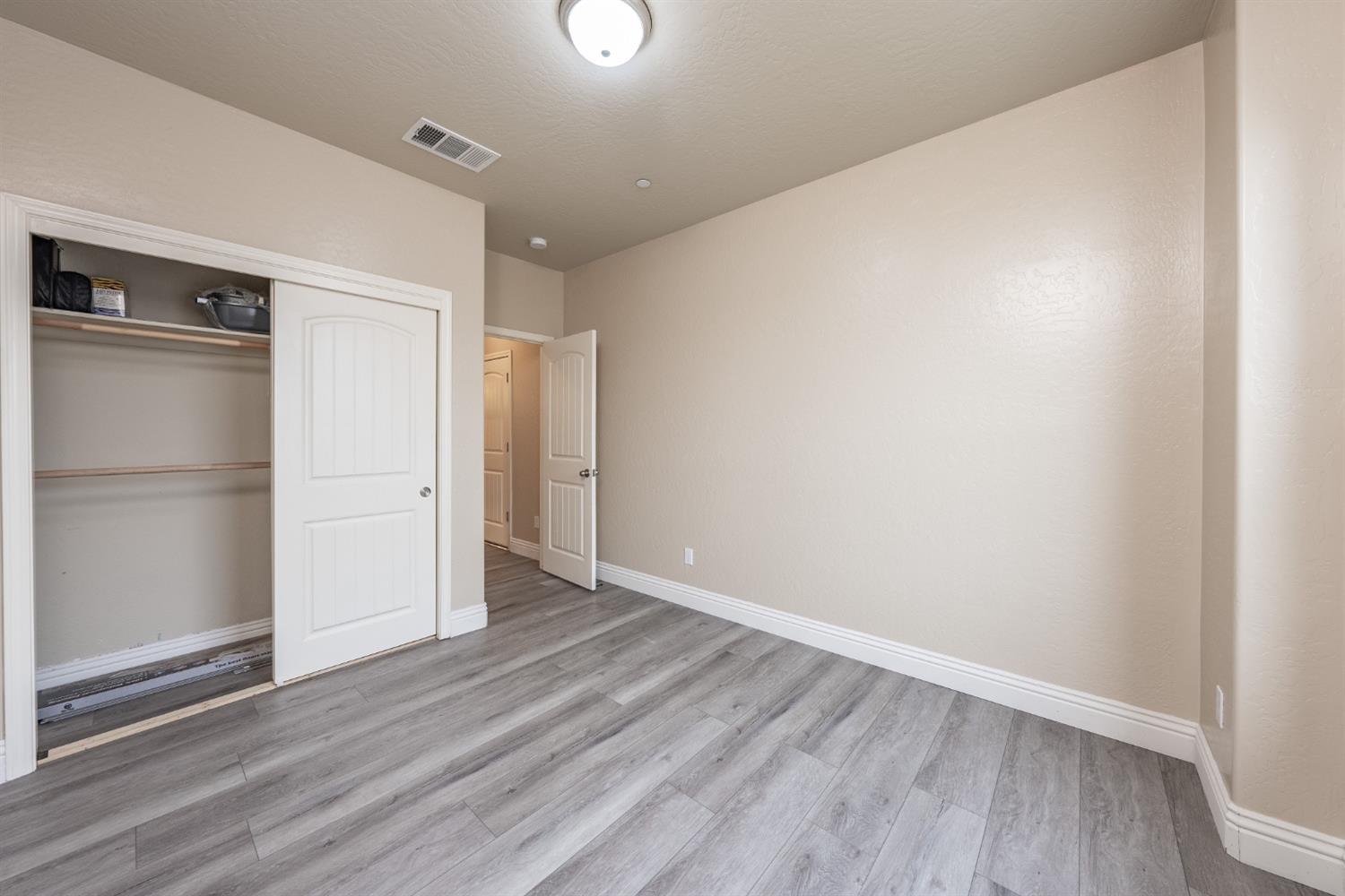 742 Strada Street Lemoore, CA 93245 - Photo 17 of 40 a view of an empty room with wooden floor closet and a window