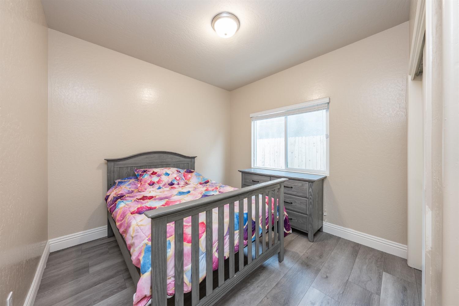 742 Strada Street Lemoore, CA 93245 - Photo 18 of 40 a bedroom with a bed and a wooden floor