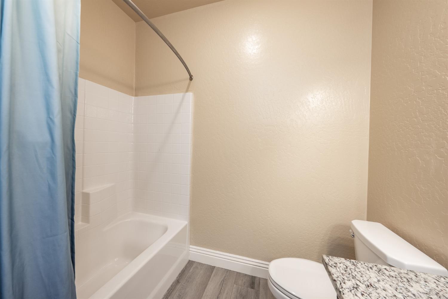 742 Strada Street Lemoore, CA 93245 - Photo 23 of 40 a white toilet sitting next to a bath tub
