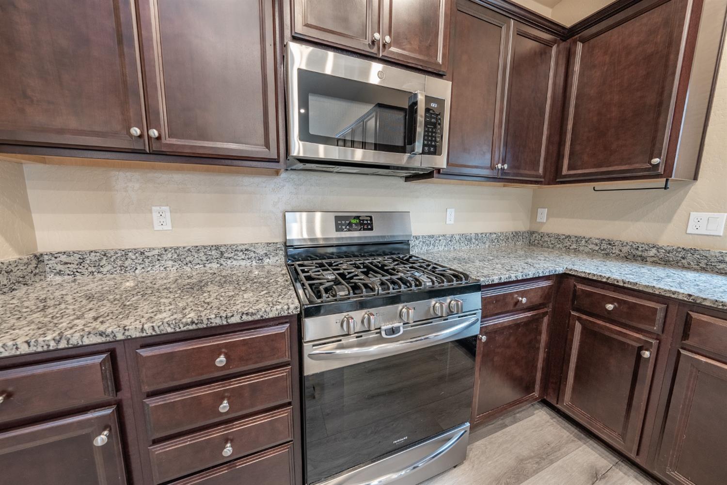 742 Strada Street Lemoore, CA 93245 - Photo 9 of 40 a kitchen with granite countertop cabinets stainless steel appliances and a counter space