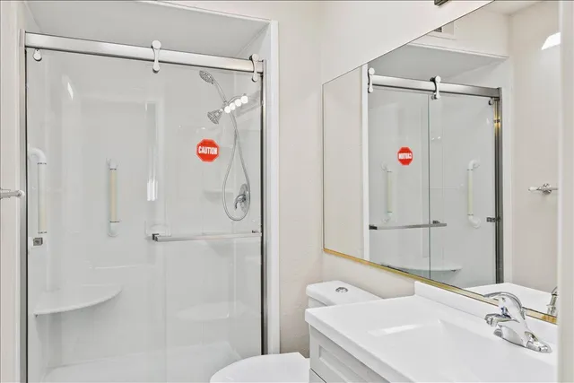 a bathroom with a shower sink vanity and toilet