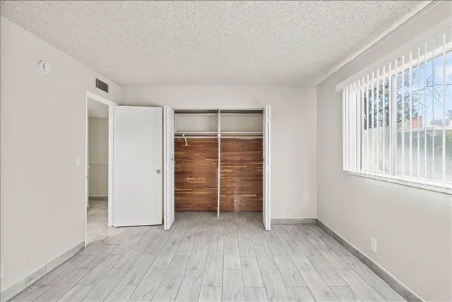 an empty room with closet and windows