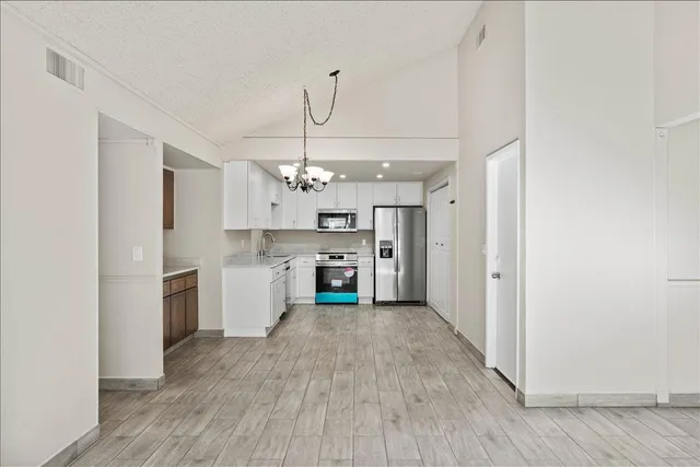 a view of a kitchen with a sink a refrigerator and a stove top oven