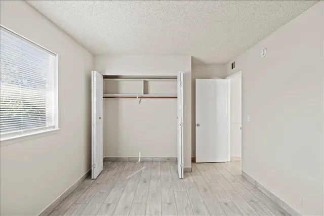 a view of an empty room and kitchen