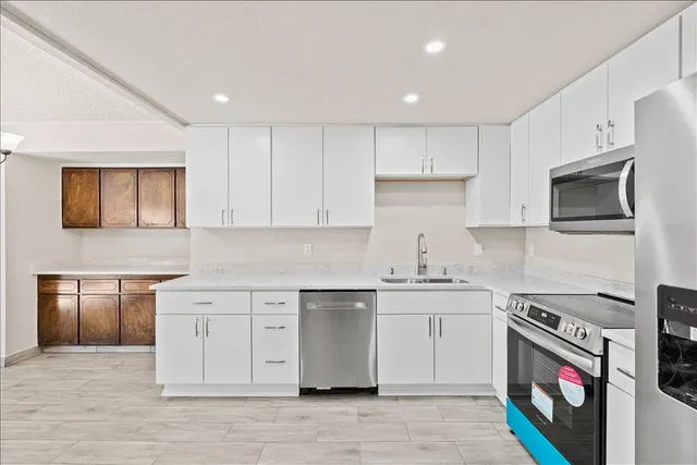 a kitchen with stainless steel appliances granite countertop a stove a sink and a microwave