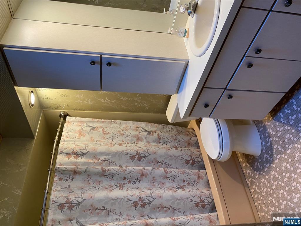 95 Atkins Terrace East Rutherford, NJ 07073 - Photo 13 of 31 a bathroom with a granite countertop toilet a sink and a mirror