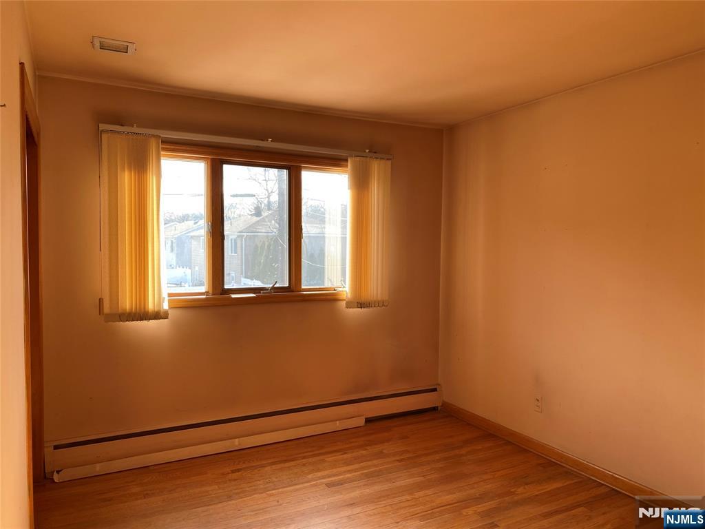 95 Atkins Terrace East Rutherford, NJ 07073 - Photo 17 of 31 a view of an empty room with wooden floor and a window