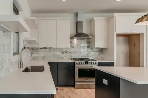 a kitchen with stainless steel appliances a sink stove and cabinets