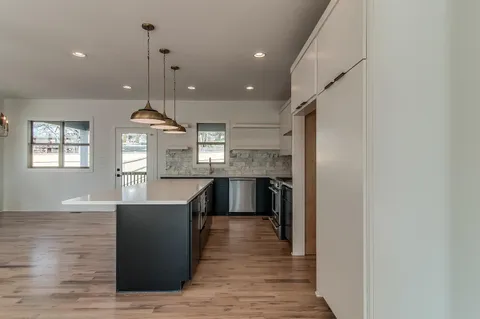 a kitchen with kitchen island a counter top space a sink and appliances