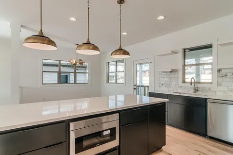 a kitchen with center island a sink appliances and a counter top space