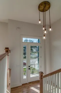 a view of a livingroom with wooden floor and a chandelier
