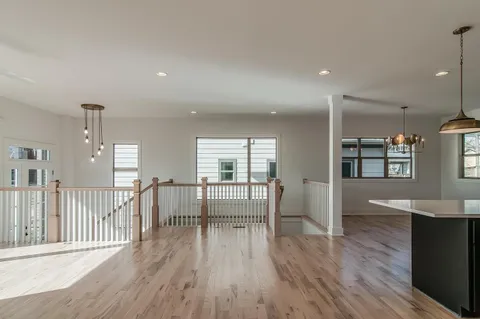 a dining room with wooden floor and windows