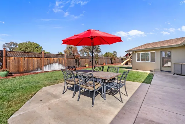 a view of a patio with a table and chairs and potted plants