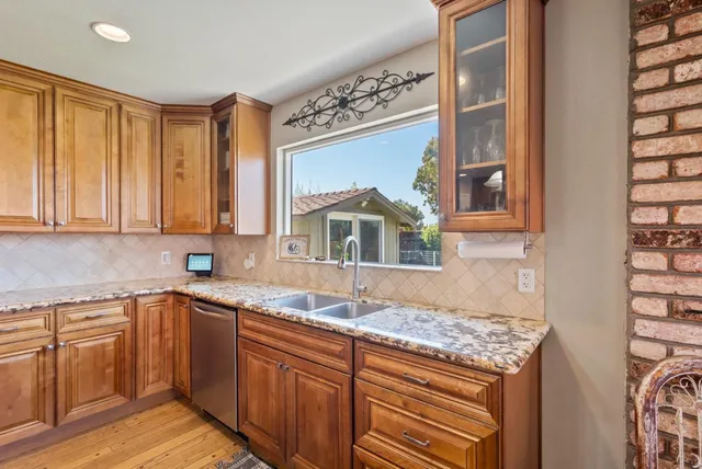 a kitchen with stainless steel appliances granite countertop a stove a sink and a microwave