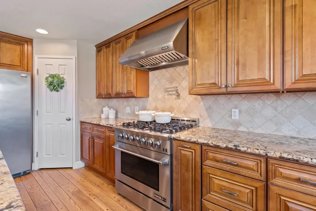 a kitchen with stainless steel appliances granite countertop a refrigerator and a sink
