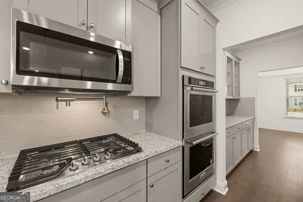a kitchen with stainless steel appliances granite countertop a stove a microwave and cabinets