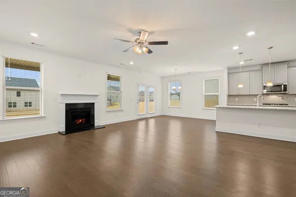 a view of empty room with wooden floor and fireplace