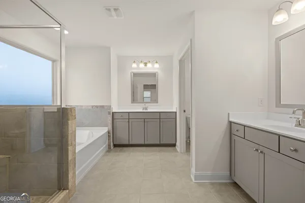 a bathroom with a double vanity sink toilet and mirror