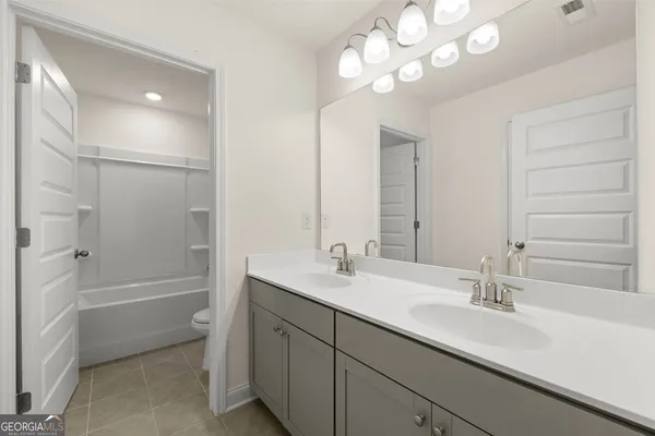 a bathroom with a sink a toilet a shower and a mirror