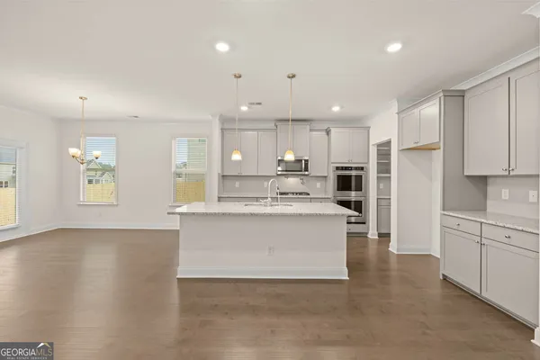 a kitchen with kitchen island a sink stainless steel appliances and cabinets