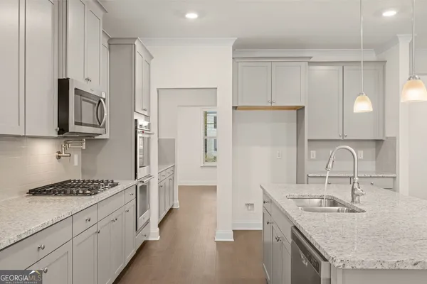 a kitchen with stainless steel appliances granite countertop a sink stove refrigerator and cabinets