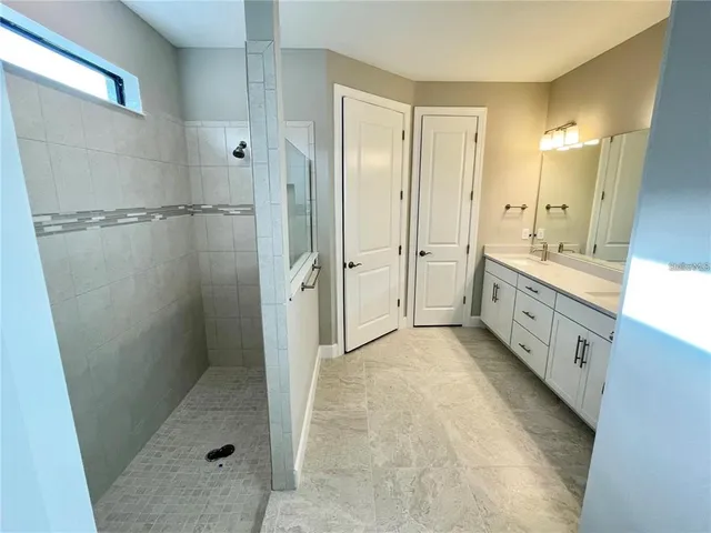 a bathroom with a glass door shower a sink and a mirror
