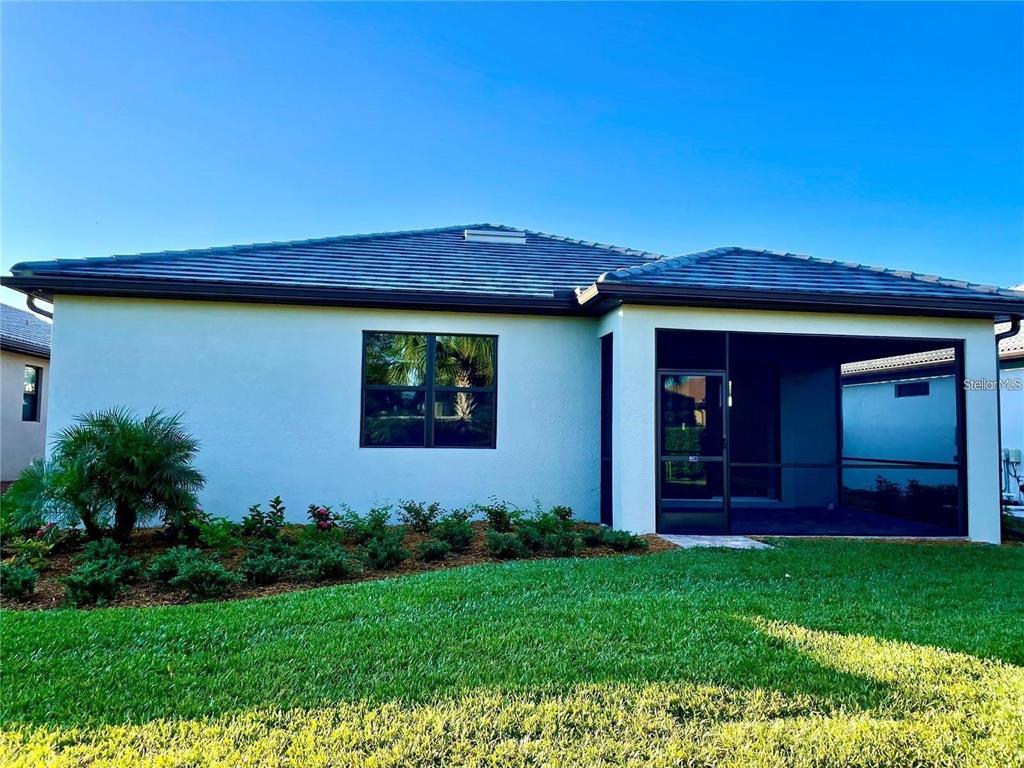 5748 Bay Pine Way Sarasota, FL 34238 - Photo 19 of 24 a view of a backyard with potted plants and a large window
