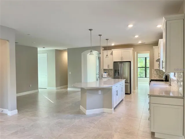 a large kitchen with kitchen island a sink stainless steel appliances and cabinets