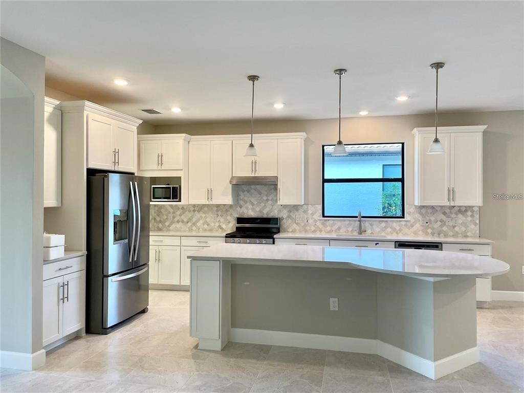 5748 Bay Pine Way Sarasota, FL 34238 - Photo 10 of 24 a kitchen with stainless steel appliances granite countertop a sink a stove a refrigerator and a oven