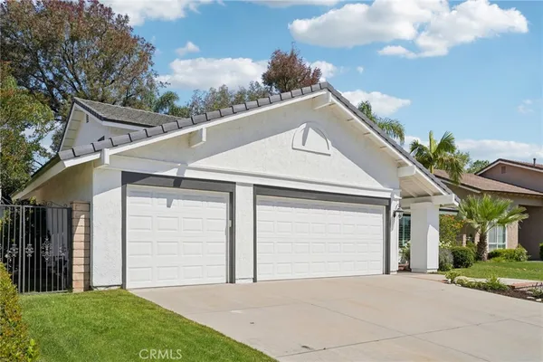 a front view of a house with a garden and garage