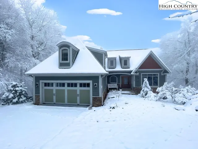 a front view of a house with a yard covered with snow in front of house