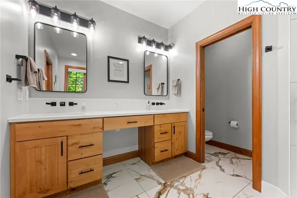 a bathroom with a sink a toilet and mirror